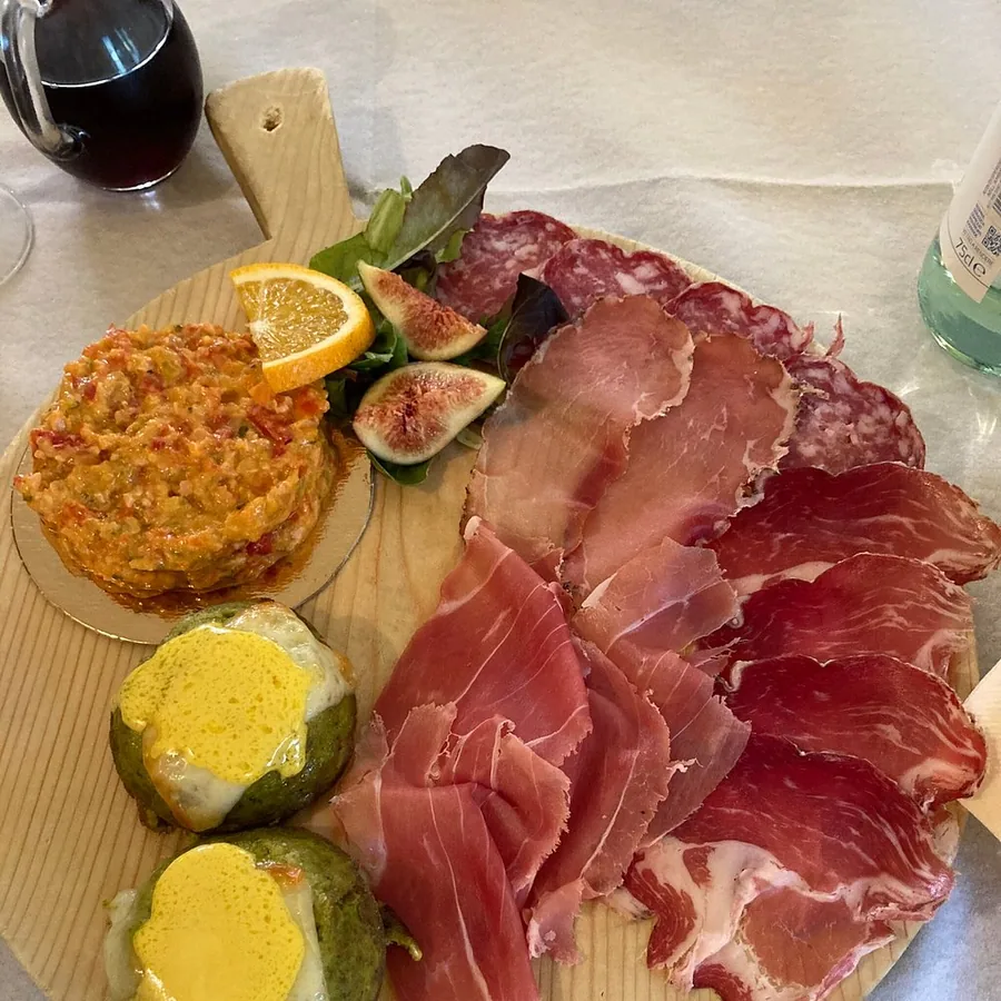 Tagliere con salumi selezionati, verdure, fichi e abbinamenti.